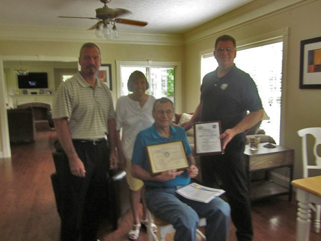 Jerry Peer receives Charles Taylor Award at his home.